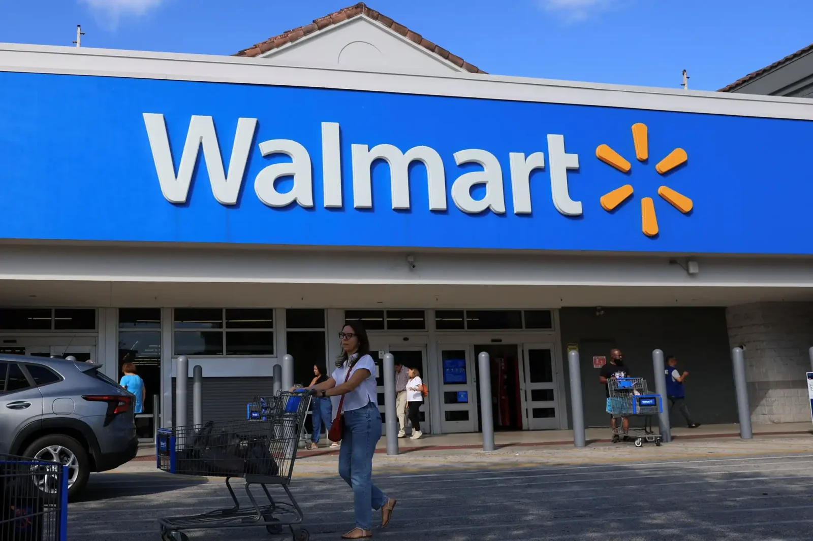 a452eb 20260323 a person with a shopping cart walks outside of a walmart store webp2000 Walmart annonce la fermeture prochaine de l'un de ses magasins achaland&eacute;s